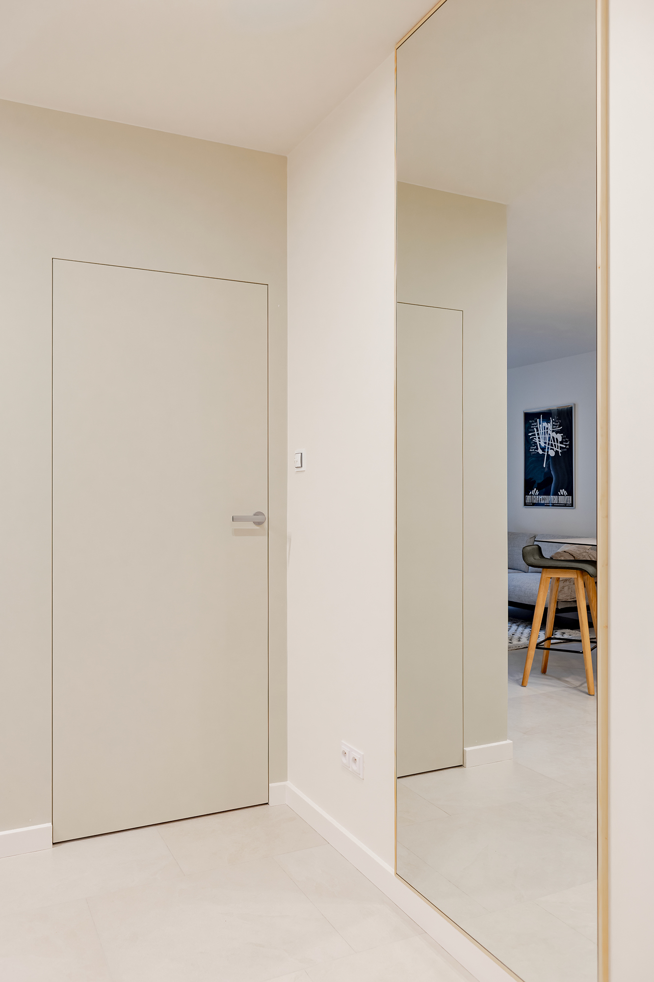 Jasne płaszczyzny w ciepłych odcieniach oraz wielka tafla lustra, powiększają wnętrze.